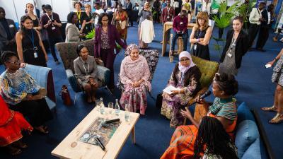 A group of women, including Amina J. Mohammed, in discussion circles at a reception area.