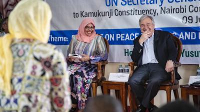 Antonio Guterres and a Kamukunji community representative smile during a discussion at a side event