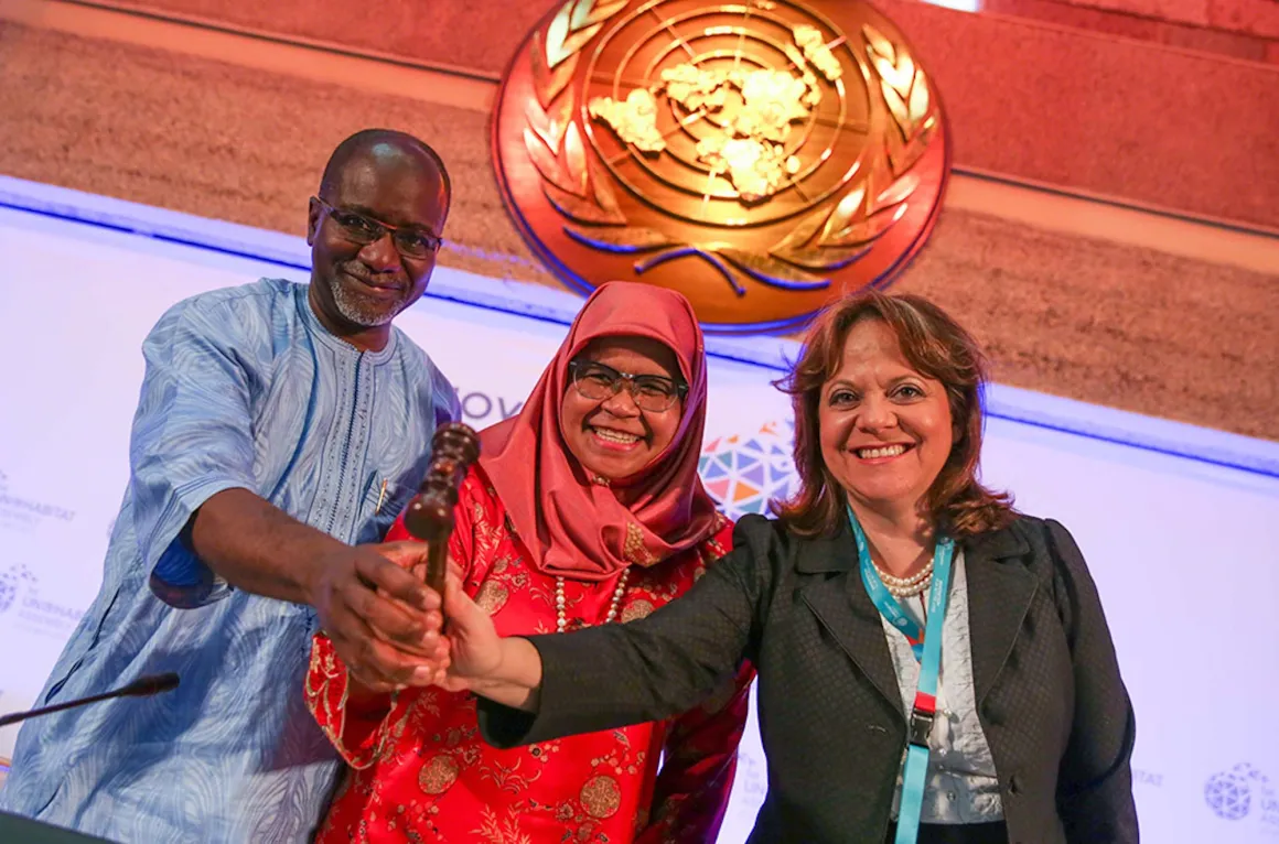 Three people hold a gavel