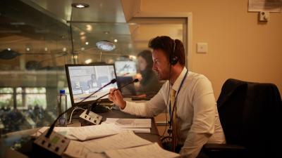 A UNON Interpreter inside a booth, providing simultaneous interpretation services for a UN conference 
